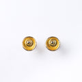 A pair of circular abstract flower earrings against a white background with rose gold plating and painted in gold and beige