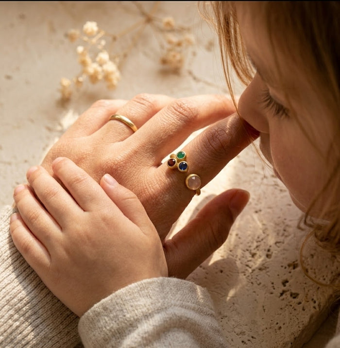 Woman wearing custom mom of three birthstone ring with personalized family gemstones on her hand