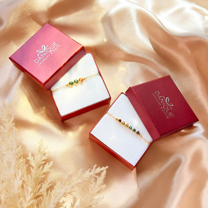 Minimalist gemstone bracelet with delicate gold chain and colorful birthstones displayed in elegant red gift boxes, perfect for stacking jewelry lovers who appreciate simple dainty designs. This handcrafted bracelet can be customized with multiple stones for mothers, grandmothers, or best friends as a meaningful birthday or anniversary gift. Lightweight everyday jewelry in sterling silver, gold filled, or rose gold for timeless layering style.