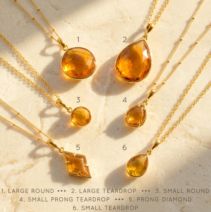 Shop our citrine necklace collection available in large, medium and small teardrops, prong set teardrop, prong set diamond, large and medium rounds on white background. Choose from satellite or cable chain. November birthstone.