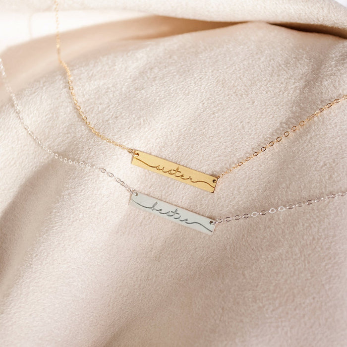 A gold and a silver necklace sits on a velvet background. Engraved bar necklace for mama bear Personalized bar necklace for mommy Custom bar necklace for new mom Engraved bar pendant for mom's birthday Personalized mama bear bar necklace Custom family engraved bar necklace Engraved bar necklace for mom of two Personalized bar necklace for mom and kids Custom mom bar necklace with children's names Engraved bar necklace for grandma Personalized mama name bar pendant