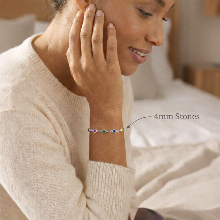 Woman wearing a custom birthstone bracelet featuring larger 4mm bezel-set gemstones on a delicate chain. Personalized family bracelet designed with children’s birthstones, handcrafted in sterling silver or gold vermeil. Elegant everyday jewelry gift for mom or grandma, combining minimalist style with meaningful personalization.