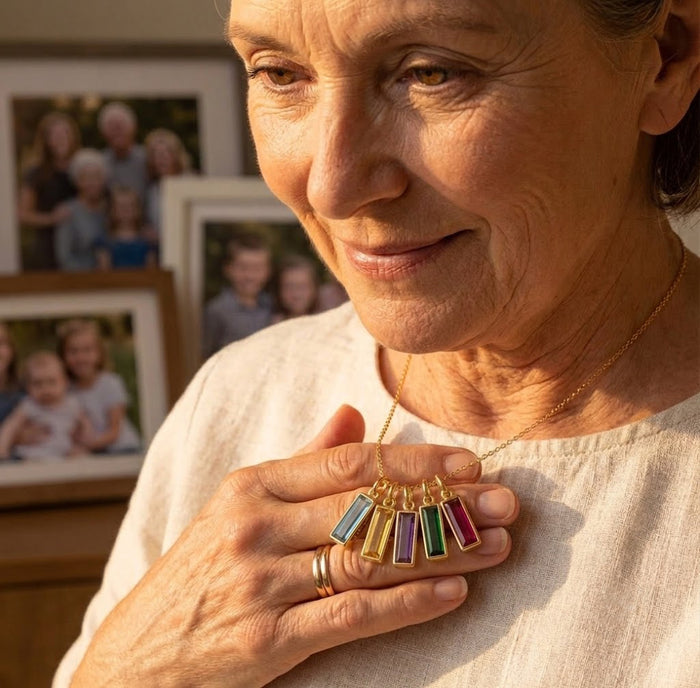 Grandma holding a personalized birthstone name bar necklace as a meaningful family keepsake gift.