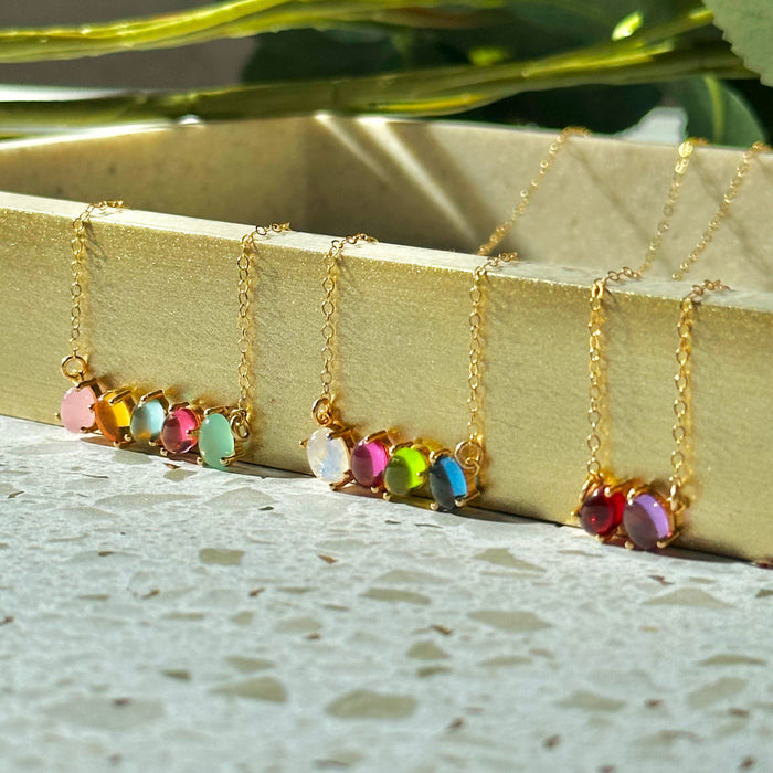 Row of custom birthstone necklaces showing different gemstone combinations for children and family members. Personalized family necklaces designed for moms and grandmas.