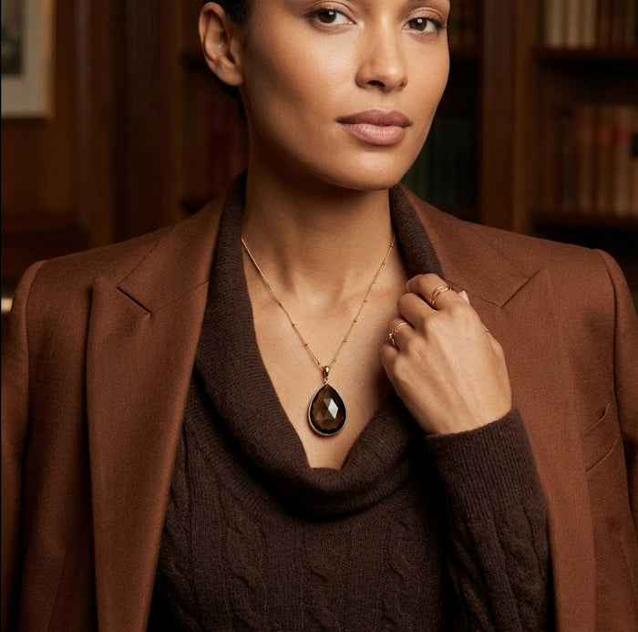 Woman wearing custom teardrop birthstone necklace with black gemstone pendant