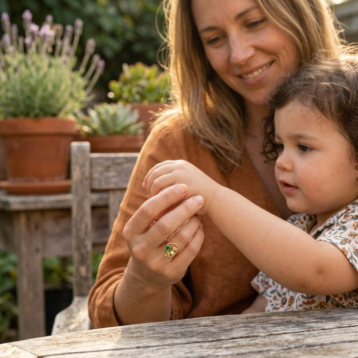 Woman wearing custom birthstone ring with colorful stones representing Mom and children.