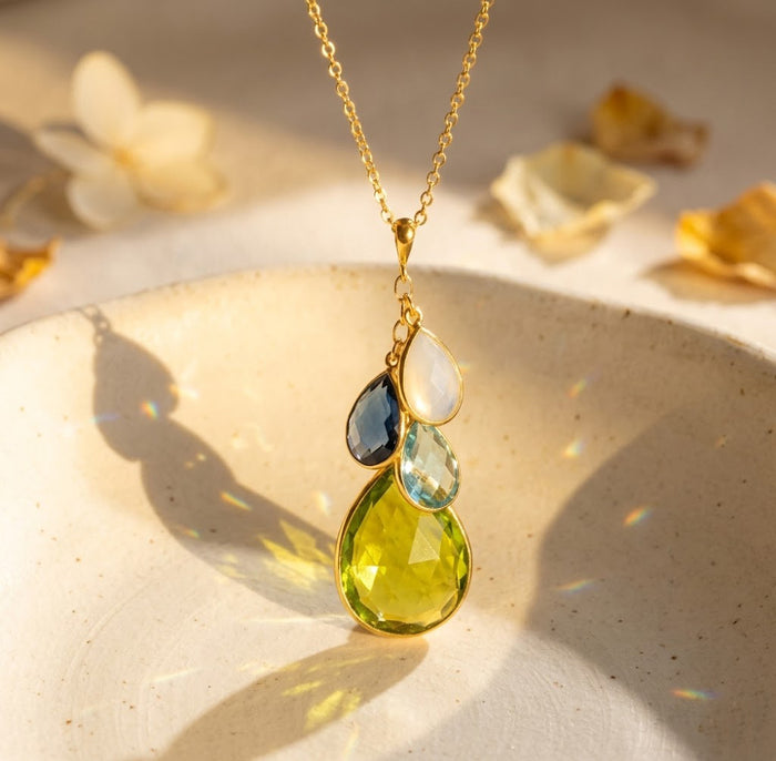 Natural birthstone necklace with cascading teardrop gemstones on warm beige background, a meaningful personalized gift for mom or grandma.