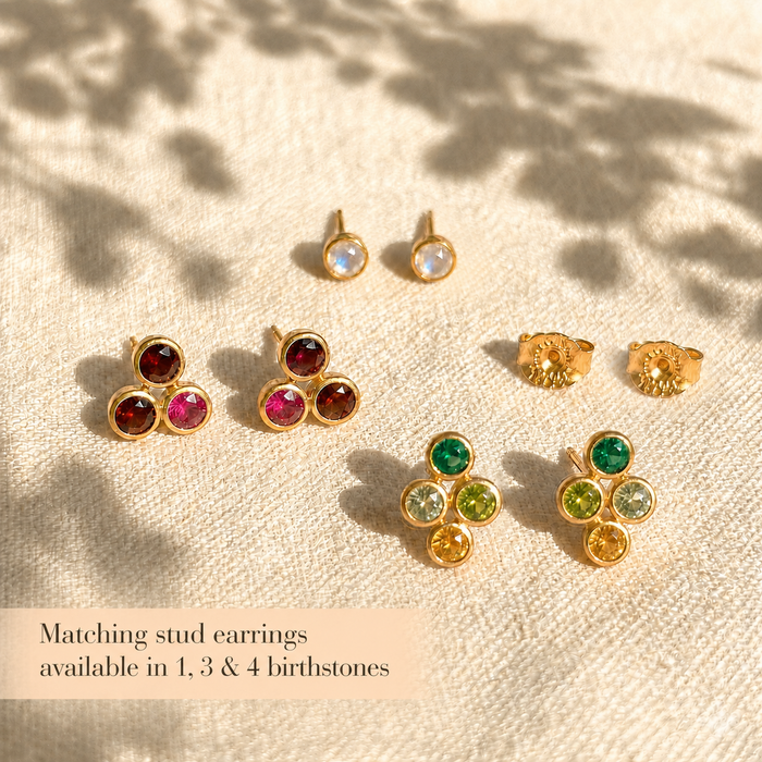 Matching stud earrings available in 1, 3, and 4 birthstone designs on a warm neutral background.