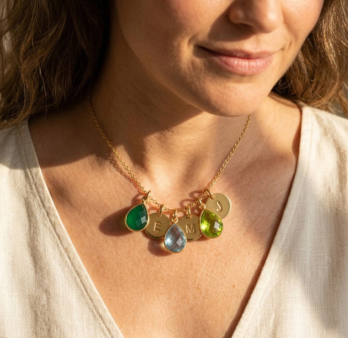 Model wearing a personalized family birthstone necklace with initial charms, styled as a meaningful gift for mom or grandma.