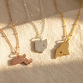 Custom state and county necklaces in silver, gold and rose gold with personalized heart cutout