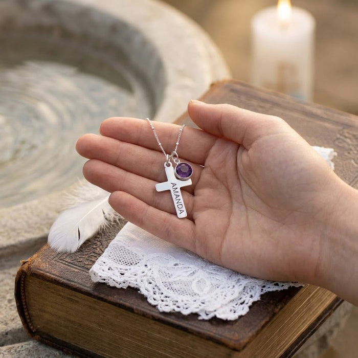 Hand holding engraved cross necklace with birthstone charm, personalized baptism or confirmation gift necklace