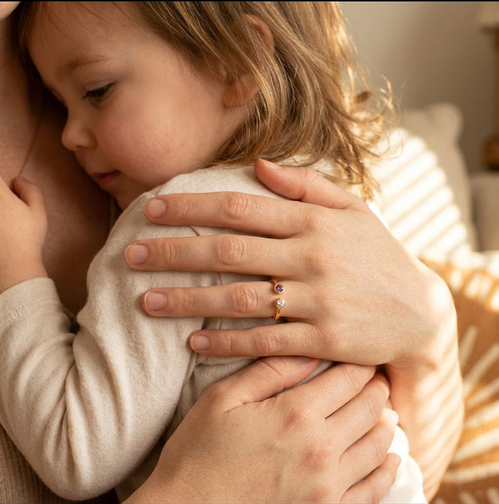 Mother wearing a personalized birthstone ring with natural gemstones, meaningful jewelry representing children or family connection