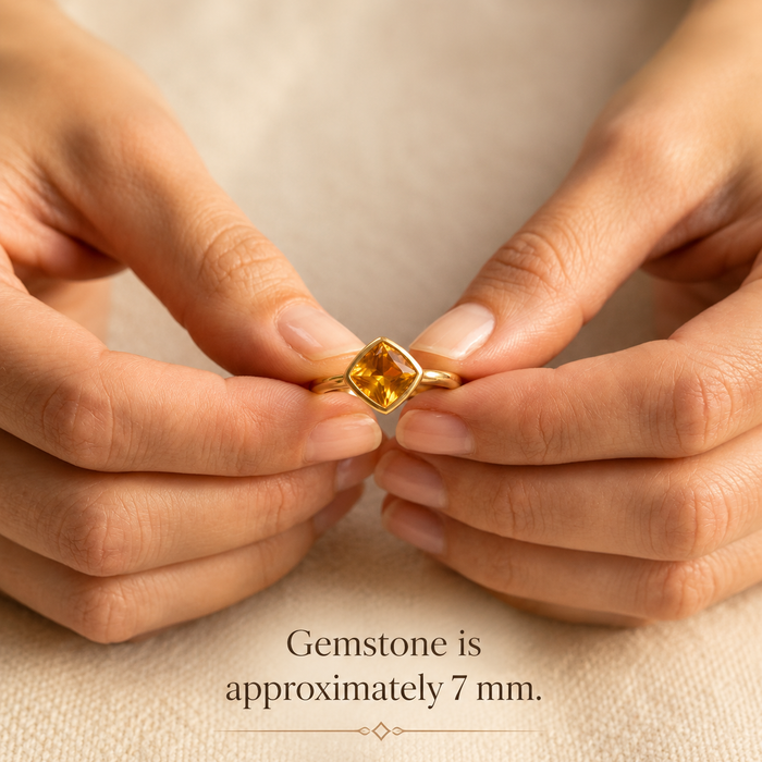 Hands holding a diamond-shaped citrine ring with an approximately 7 mm stone