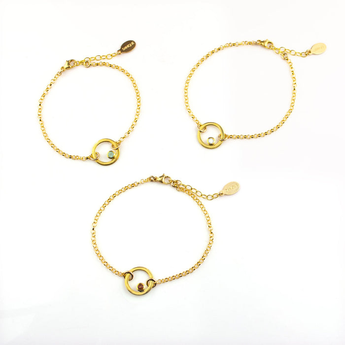 three gold plated open circle pendant charm birthstone bracelets featuring aqua chalcedony, clear quartz and garnet birthstones. March birthstone, January birthstone, april birthstones. gemstone jewelry on white background.