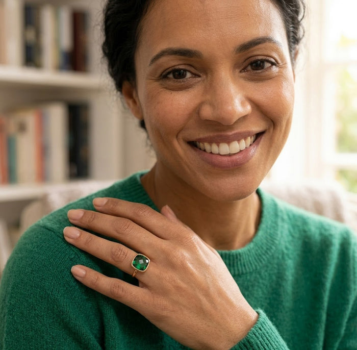 Model wearing emerald quartz cushion ring near her shoulder with green sweater, showing ring scale and everyday styling.