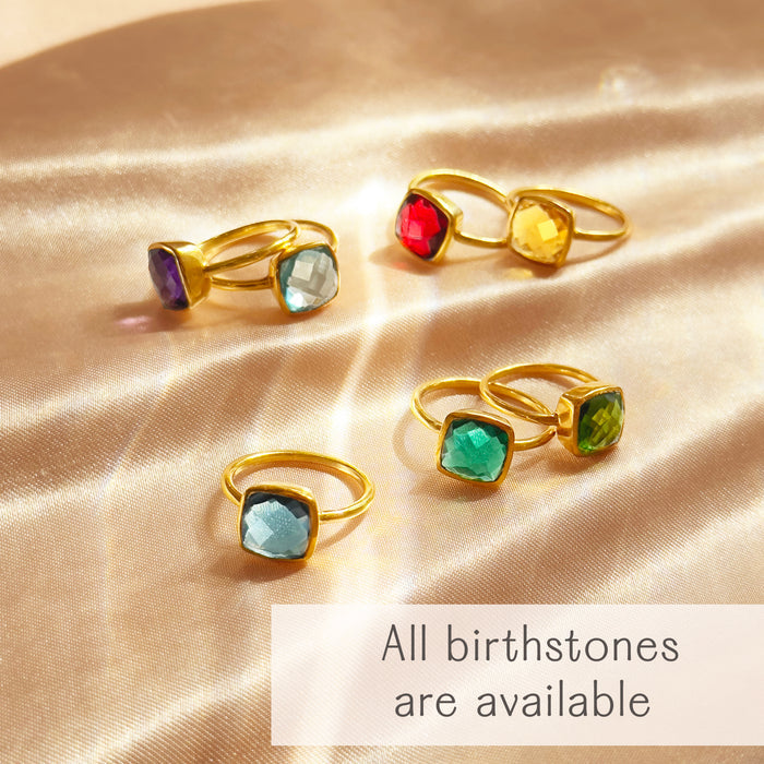 Colorful cushion gemstone rings displayed together with text noting that all birthstone options are available.