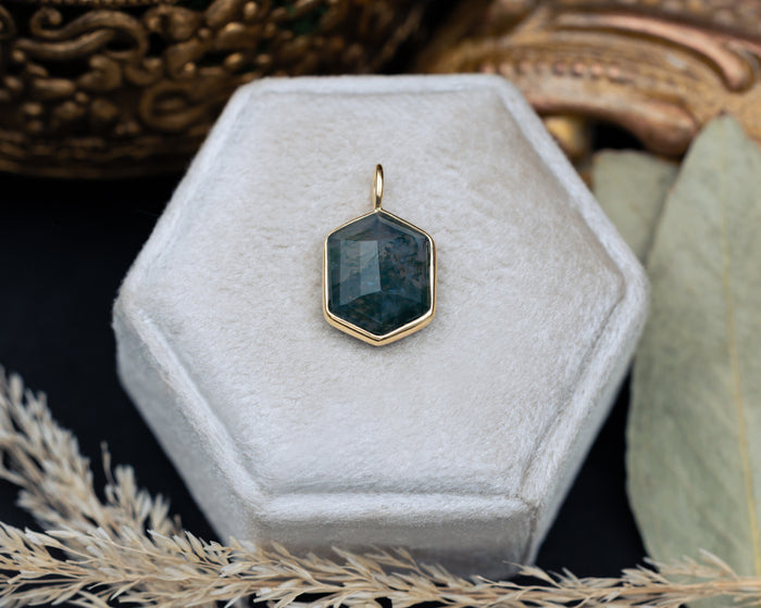 Hexagonal pendant on a white hexagonal stand with a decorative background