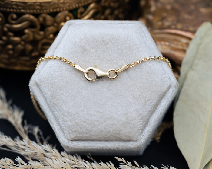 Chain clasp on a hexagonal white jewelry box with decorative background