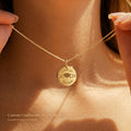 Gold personalized graduation disc necklace worn on model, engraved with Class of 2026, graduate name, and graduation cap design.