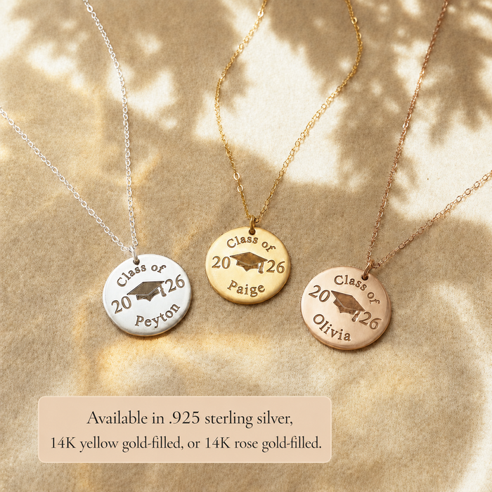 Gold, silver, and rose gold graduation disc necklaces engraved with Class of 2026, names, and graduation cap details.