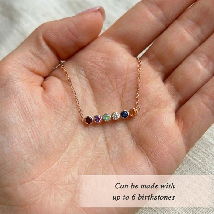Macro detail of faceted gemstone birthstone bar necklace, highlighting colorful stones and fine gold chain in a modern minimalist family jewelry design