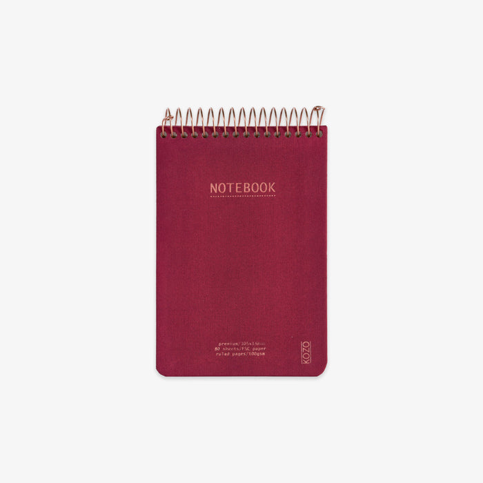 Red notebook with spiral binding on a white background