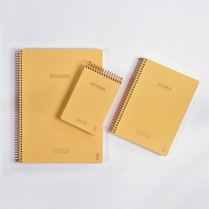 Three yellow notebooks with spiral binding on a white background