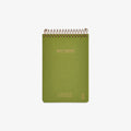 Green notebook with spiral binding on a white background