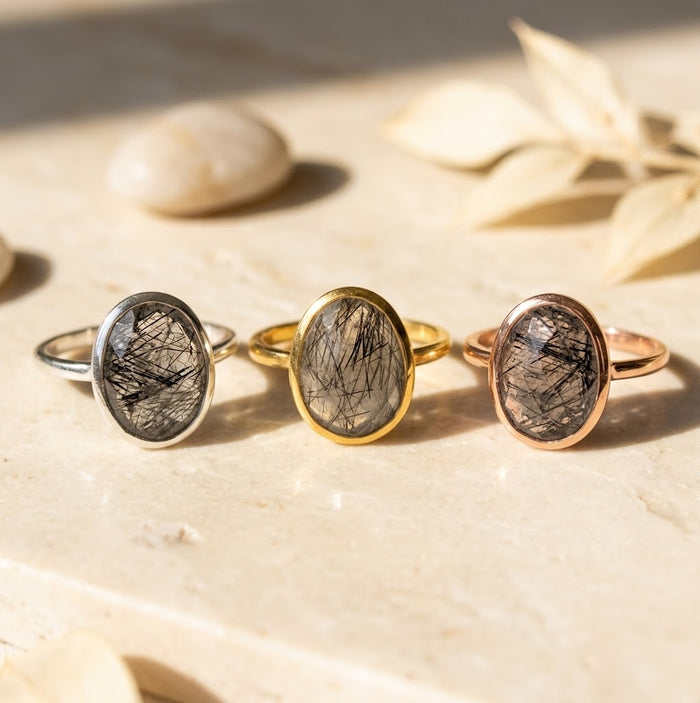 Black rutilated quartz and gemstone teardrop rings in mixed metal finishes