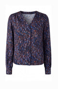 A women's long-sleeve blouse with a V-neckline, featuring an abstract, textured multicolor pattern in navy, blue, red, and white, displayed on a clean white background.