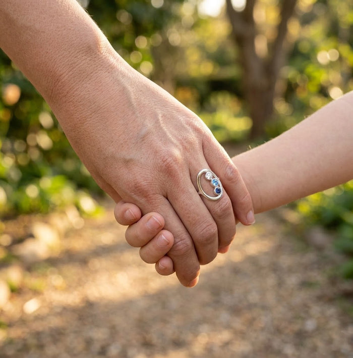 Mom wearing gold mom ring with three birthstones for kids