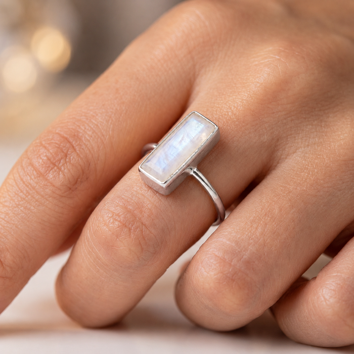Sterling silver moonstone bar ring worn on a hand, showing the small rectangular gemstone ring style.