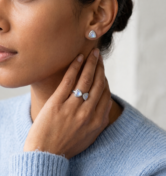 Model wearing sterling silver moonstone triangle ring and matching studs with blue sweater.