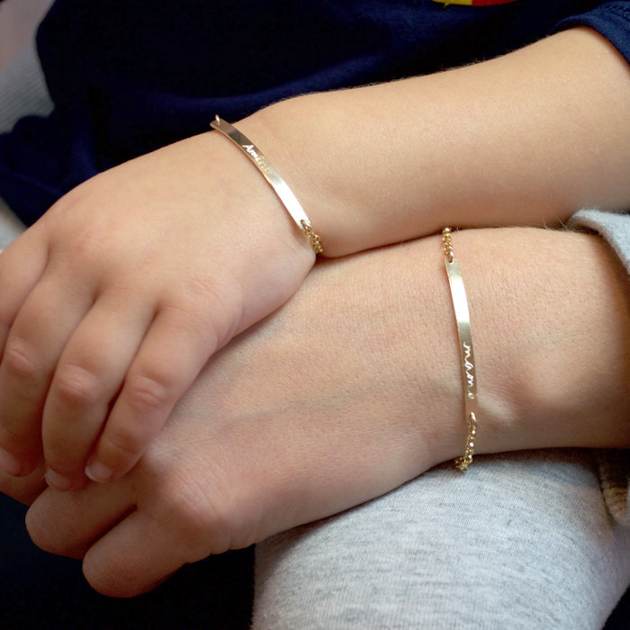 Matching gold skinny bar bracelets on an adult and child, personalized with custom Morse code engraving on a minimalist bar, delicate gold chain design, meaningful mother-child jewelry set, perfect personalized gift for mom, new mom, or daughter, handcrafted in sterling silver or gold-filled options with hidden message customization.