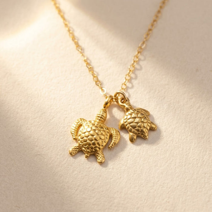 Mama and baby turtle necklace with two gold sea turtle charms on a delicate chain, meaningful mother and child jewelry gift.