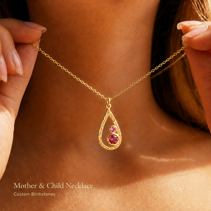 Custom mother and child birthstone necklace with open teardrop pendant and colorful birthstones, shown on model in warm natural light.