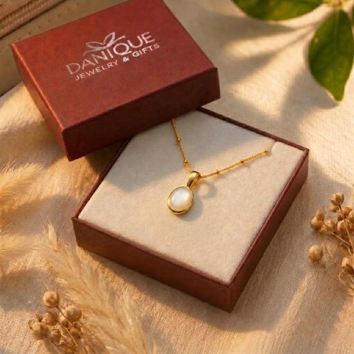 Oval Mother of Pearl pendant necklace displayed in a Danique Jewelry gift box with floral styling