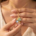 Personalized birthstone necklace for mom with cascading teardrop gemstones and initial charms, a custom family necklace representing children or grandchildren.