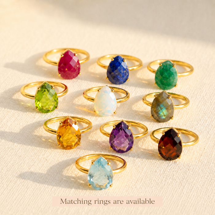 Gold teardrop stud rings available in a variety of birthstones, including natural rainbow moonstone and colorful gemstone options.