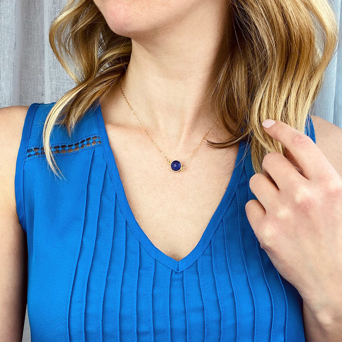 Model in blue top is wearing a gold filled connector necklace with a single lapis birthstone.