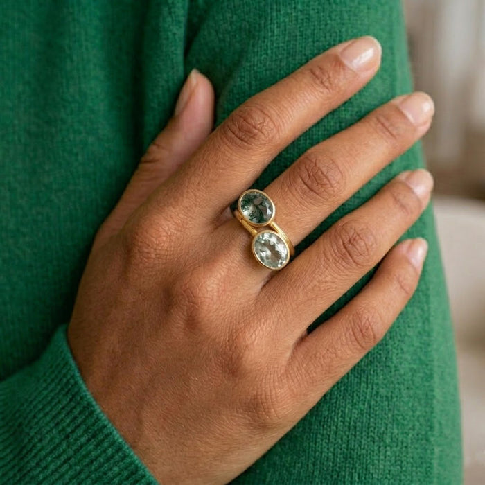 Model wearing stacked gemstone rings with moss agate and green stones, showing mix and match ring styling.