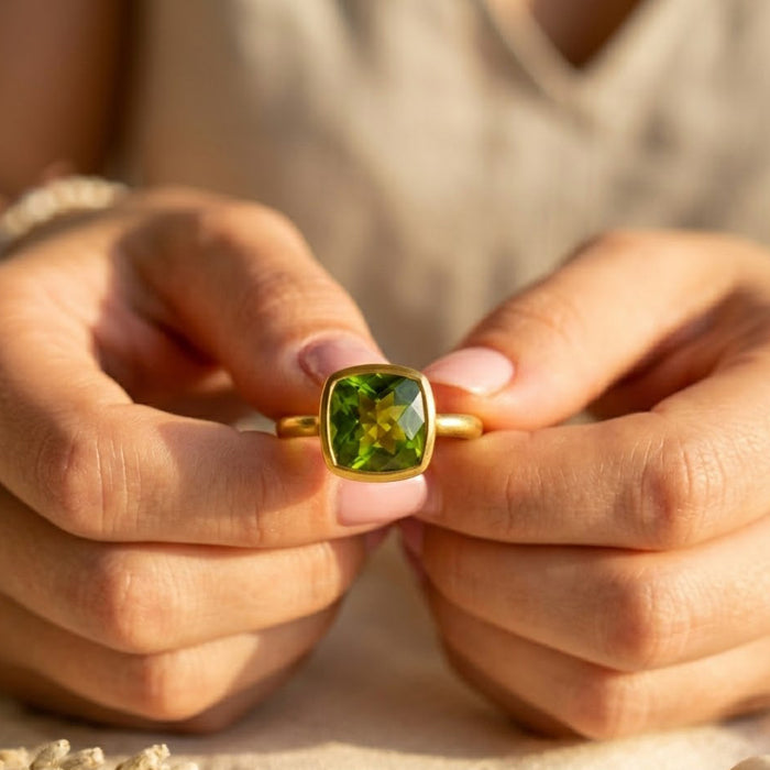 Peridot gemstone ring worn on hand with bold green color and gold band