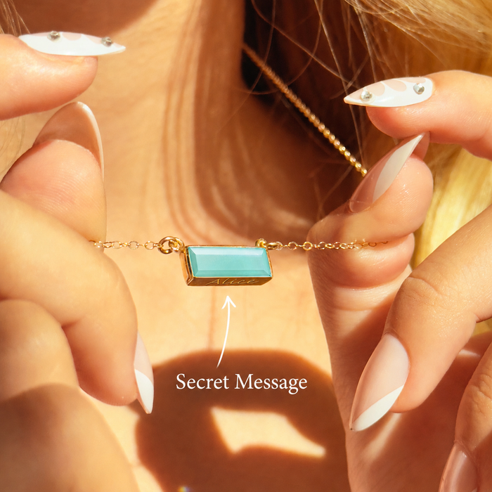 Personalized aqua chalcedony bar necklace with secret message engraving shown on model in warm sunlight.