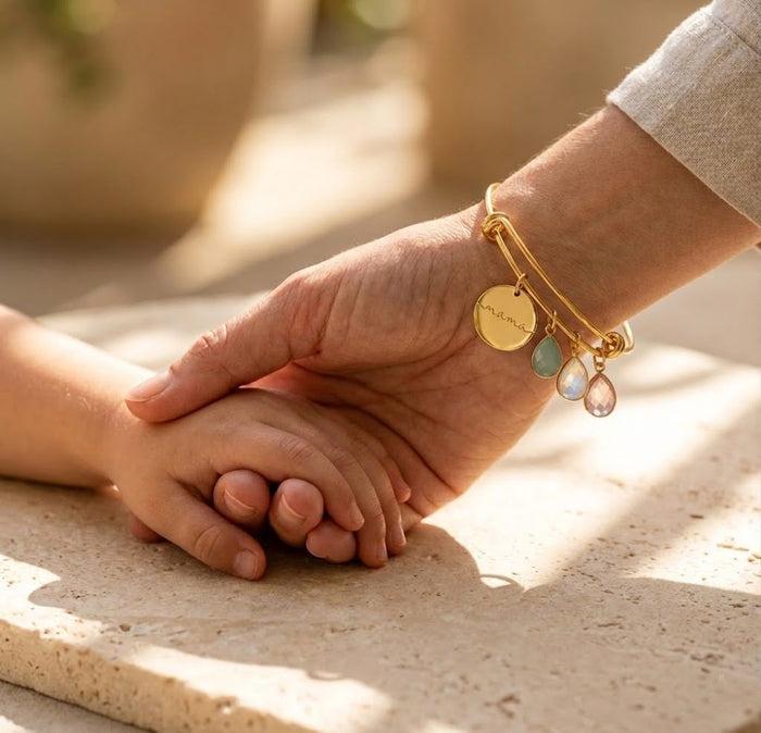 Personalized birthstone bangle bracelet for mom shown on wrist with engraved charm and colorful family birthstone stones.