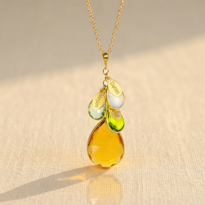 Gold family birthstone necklace with large mother stone and smaller children's teardrop birthstones