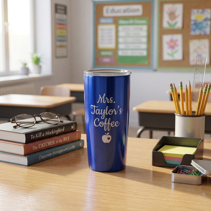 Blue personalized teacher tumbler engraved with “Mrs. Taylor’s Coffee,” styled on a classroom desk with books and pencils.