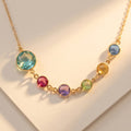 Personalized mother’s birthstone necklace with large center gemstone for mom and smaller colorful birthstones representing children in a meaningful family design