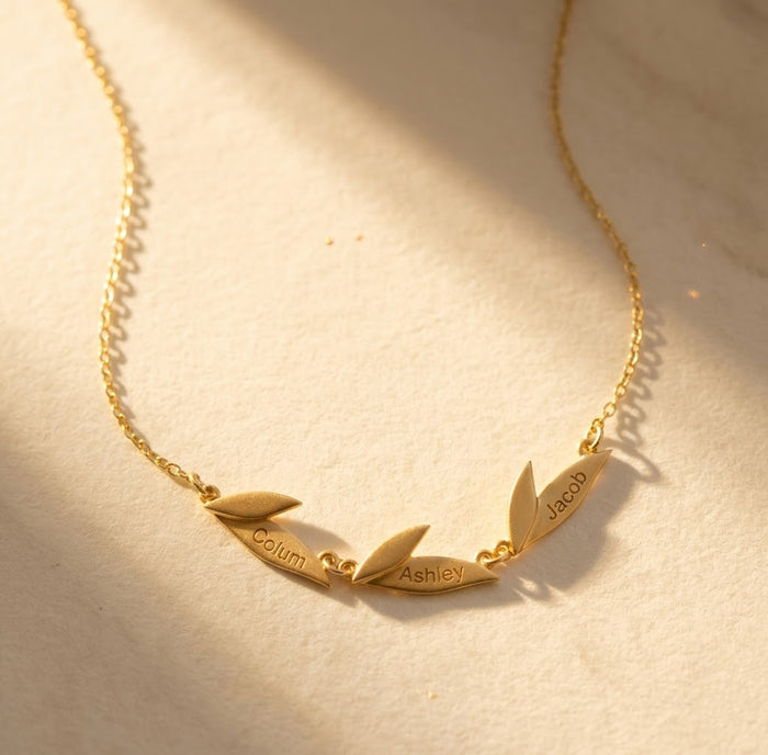 Personalized leaf necklace with engraved names on gold leaf charms, a meaningful custom family necklace for mom or grandma with children’s or grandchildren’s names.