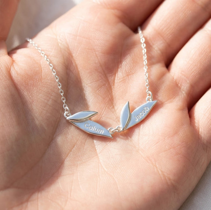 Sterling silver personalized leaf necklace shown in hand, featuring engraved leaf charms for a custom family keepsake necklace.