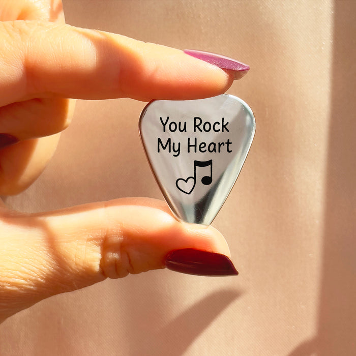 Close-up of personalized stainless steel guitar pick engraved with “You Rock My Heart” and music notes, ideal as a custom engraved gift for musicians, boyfriends, husbands, or dads on Father’s Day, anniversaries, weddings, or birthdays.